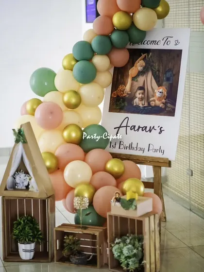 The welcome setup for Aaran's first birthday. A personalized sign is surrounded by a beautiful balloon arrangement and rustic wooden crates with a mini teepee prop.
