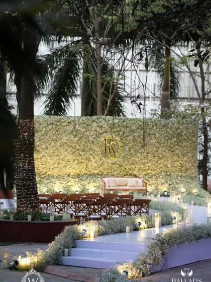 An ethereal all-white reception. The aisle and backdrop are adorned with clouds of baby's breath, while flickering candles cast a warm, romantic glow, creating a scene straight out of a fairy tale.