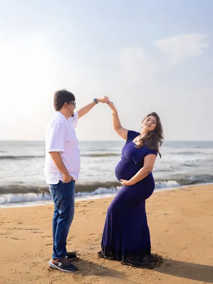 A playful dance on the sand. We encourage natural interactions to capture the genuine love and happiness you share as a couple during your beach maternity session.