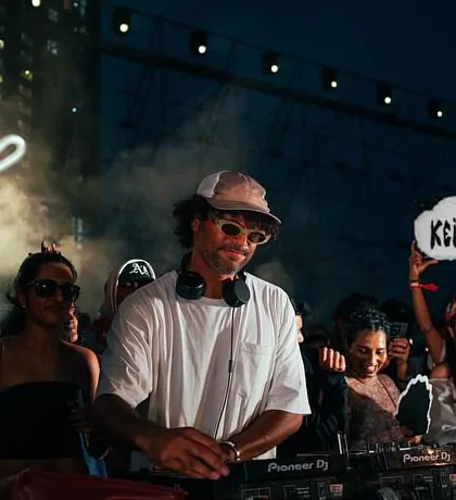 A fan holding up a "Keinemusik" sign at the &ME show, showing their love for the music collective. It's a community.