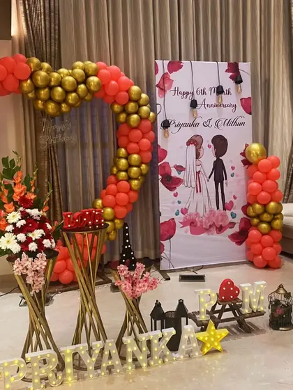 A grand 6th-anniversary celebration for Priyanka and Mithun. The centerpiece is a massive heart-shaped balloon arch in red and gold, creating a bold and romantic statement.