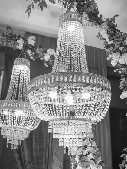 This black and white shot emphasizes the timeless elegance of the crystal chandeliers used in our floral arch design. The intricate details of the crystals create a sense of opulence and grandeur.