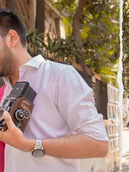 A detail shot from a Mumbai pre-wedding session, showing the groom holding a vintage camera. This adds a layer of storytelling and personality to the shoot.