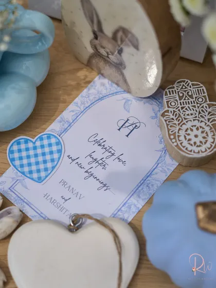 A close-up of the custom stationery and small decorative items, including a Hamsa hand block stamp and a heart-shaped tag.