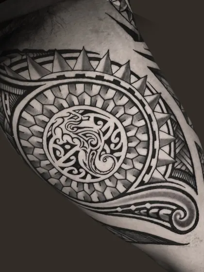 A detailed close-up of a Polynesian sleeve. You can see the precision in the geometric patterns, from the honeycomb shapes to the sharp, repeating spearhead motifs, all shaded to create depth.