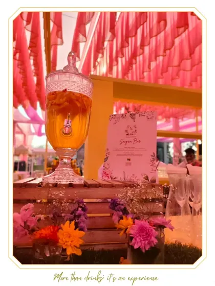 A beautiful sangria dispenser at a wedding, surrounded by fresh flowers. This self-serve concept is a great way to offer a delicious and visually appealing drink option.