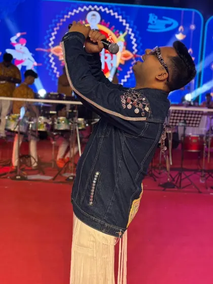 Singing my heart out on stage. The energy of the live band and the crowd is what fuels my performance as a Garba night host.