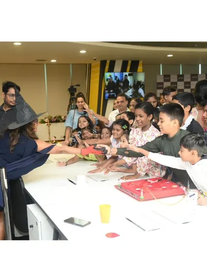 An instructor, dressed as a science wizard, engages a crowd of eager children. They are mesmerized by the experiments and can't wait to get their hands on the magic of science.