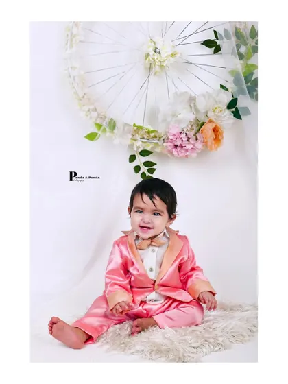 A charming solo portrait of a baby boy dressed in a dapper pink suit. We also capture individual shots of your little one during family sessions to highlight their budding personality.