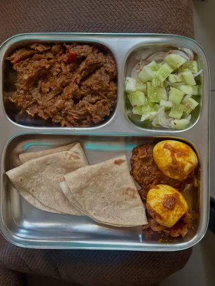 This eggetarian meal includes chapati with baingan bharta (roasted eggplant mash) and a side of masala boiled eggs and salad.