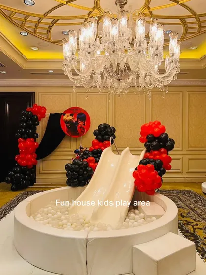 Our white ball pit with a double slide, decorated with red and black balloons for a themed birthday party in an elegant ballroom.