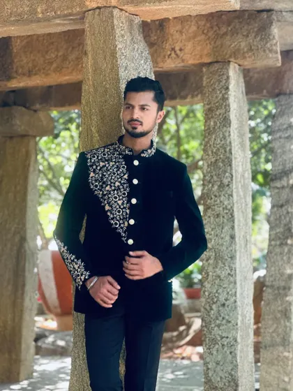 A full-length pose showcasing a dark velvet bandhgala, perfect for a winter wedding collection or formal event.