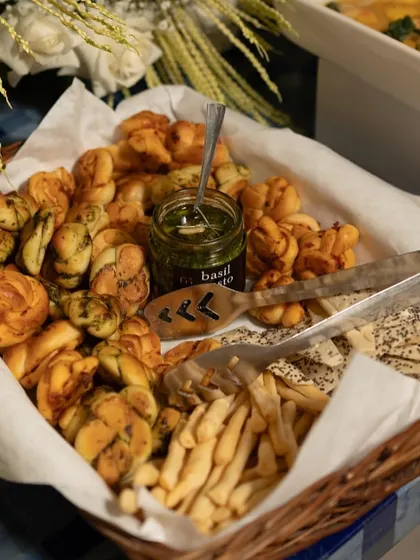 A basket of our freshly baked pesto and chili cheese bread twists, served with a jar of basil pesto for dipping. This is a perfect addition to a buffet or grazing table, offering a rustic yet gourmet touch.