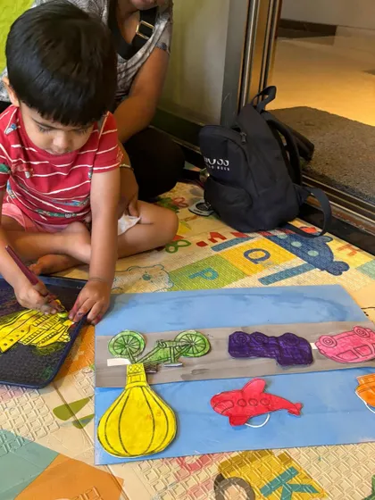 This little one is completely absorbed in his transport-themed art project. I provide various cutouts like cars, planes, and hot air balloons for them to paint and arrange, encouraging creative expression.