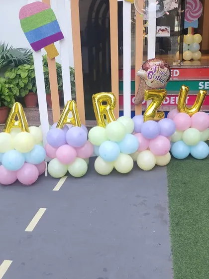 Personalization is key. Here, I've spelled out the birthday girl's name, "Aarzu," with large foil balloons integrated into colorful balloon stands.