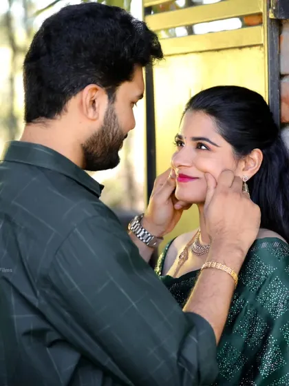 A playful and affectionate moment, showing the groom gently pinching the bride's cheeks during their Coimbatore pre-wedding shoot.