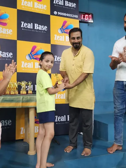 Our young winner, Shree Aadhya, receiving her trophy at the Zeal Badminton Academy.