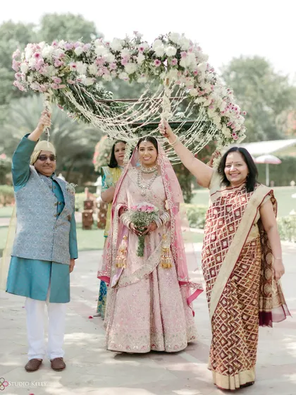 The bride's entry with her parents under a beautiful floral canopy at the Jai Mahal Palace.