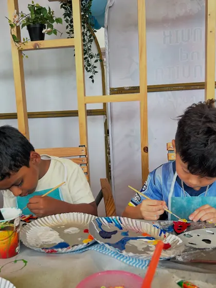 A close-up of two boys deeply focused on their craft. It's amazing to see how absorbed they get in the process of making something with their own hands.