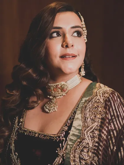A close-up of the bride's reception look. We paired her velvet outfit with understated jewelry and classic Hollywood waves for a timelessly glamorous feel.