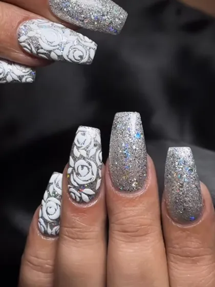 A stunning silver glitter set with intricate white rose art. This is a perfect look for a winter party or a glamorous bride.