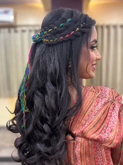 A side view of the unique Mehendi hairstyle, featuring colorful threads braided into the hair for a playful and festive touch.