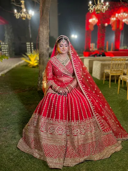 A full portrait showcasing the grandeur of her bridal attire. The makeup provides a perfect, polished finish to her regal look.