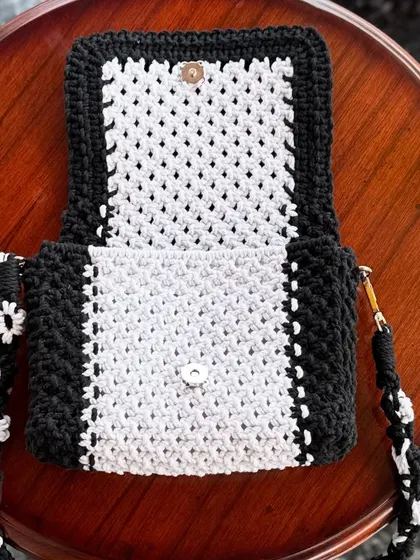 Here you can see the inside of the black and white bag, showing the magnetic clasp and the detailed knotwork.