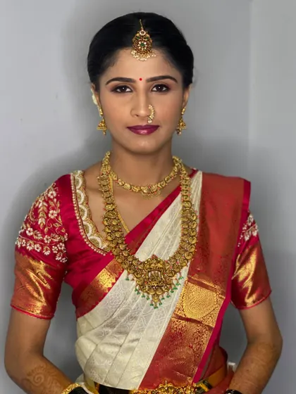A direct portrait of Vathsala, showcasing the symmetry and precision of the makeup and jewellery placement, key to a polished bridal look.