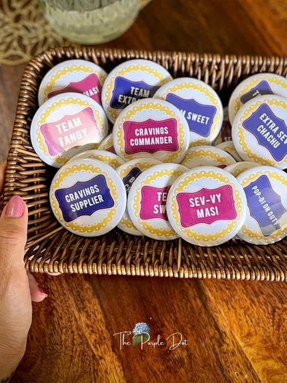 These fun, custom-made badges were for a chaat-themed baby shower celebration. With labels like "Cravings Commander" and "Team Tangy," they added a playful and personal touch for all the guests.