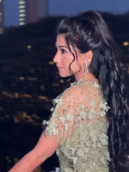 A side view of the high textured ponytail, showing its volume and bounce.