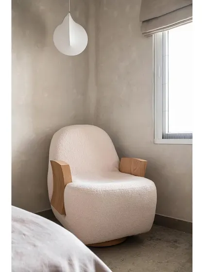 Every serene home needs a cozy reading nook. In this Japandi-style bedroom, I designed a custom lounge chair with a soft, textured fabric and sculptural wooden arms. It’s the perfect corner to unwind with a book, bathed in natural light.