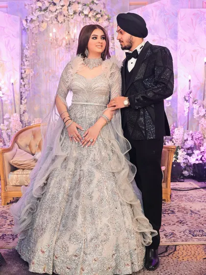 A formal portrait of the couple against a backdrop of soft purple and white florals. Their elegant attire and the romantic decor create a picture-perfect engagement memory.