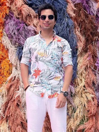 Feeling happy and blessed against a stunning, colorful floral wall. This was the perfect backdrop for a boho-themed wedding event, kicking off an amazing journey.