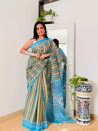 This striped cotton mulmul saree in shades of green and blue is very modern and chic. It's a great option for someone who likes contemporary prints.
