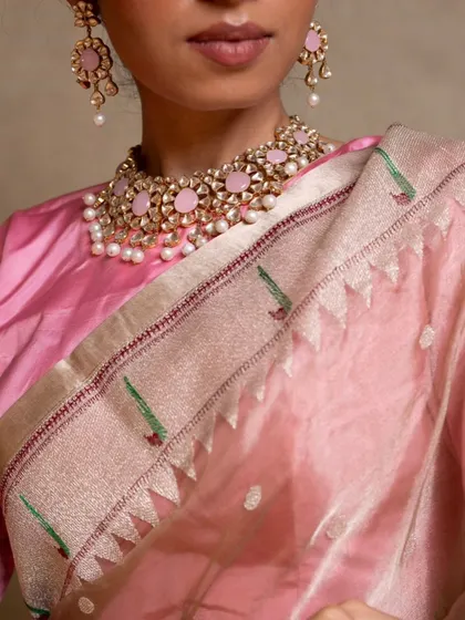 A close-up of the Paithani border, known for its intricate parrot and floral motifs woven with colorful silk threads.