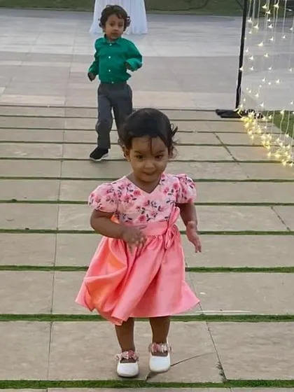 A sweet moment of play in a dusty pink floral dress. The comfortable design allows for easy movement, making it practical for active toddlers.