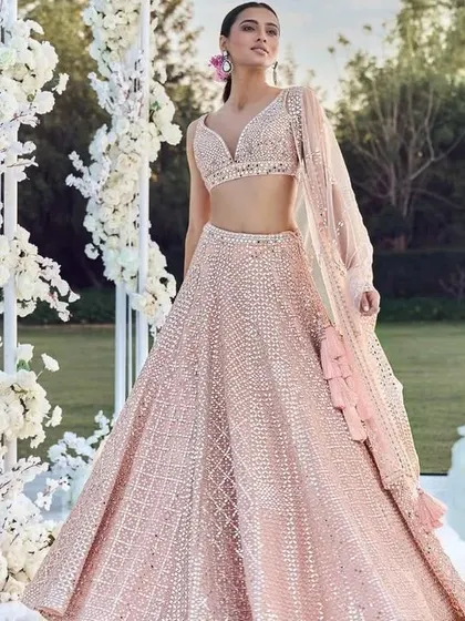 This light pink sequined lehenga is a beautiful choice for a day wedding or reception. I can design a similar piece with a focus on soft colors and sparkling details.