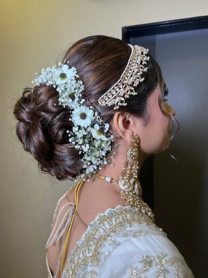 A detailed shot of the beautiful floral bun, adorned with baby's breath and daisies.