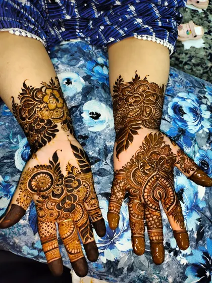 A beautiful design with a mix of floral and traditional motifs. The dark fingertips are a classic touch.