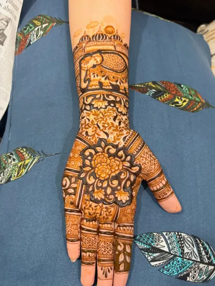 A single-hand design showcasing a beautiful floral mandala on the palm and an elephant motif on the wrist, perfect for an engagement or for a bridesmaid.