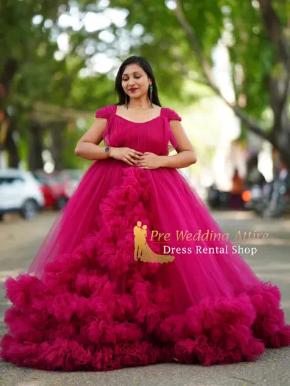 The magenta ruffled gown in a standing pose, showing how the ruffles create a stunning, high-fashion silhouette.