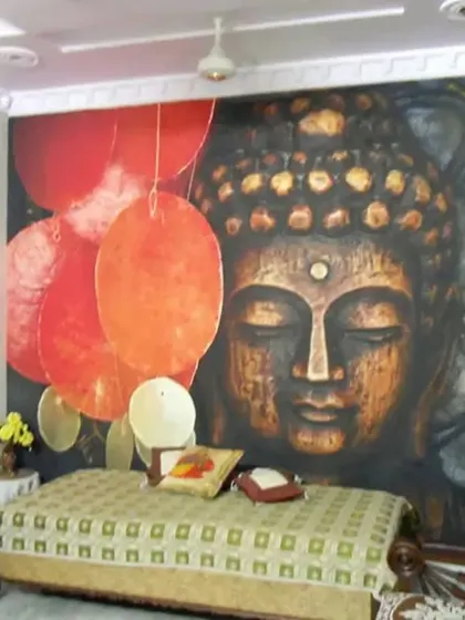 A large, impactful Buddha face mural serves as the backdrop for this living area, creating a space for relaxation and contemplation.