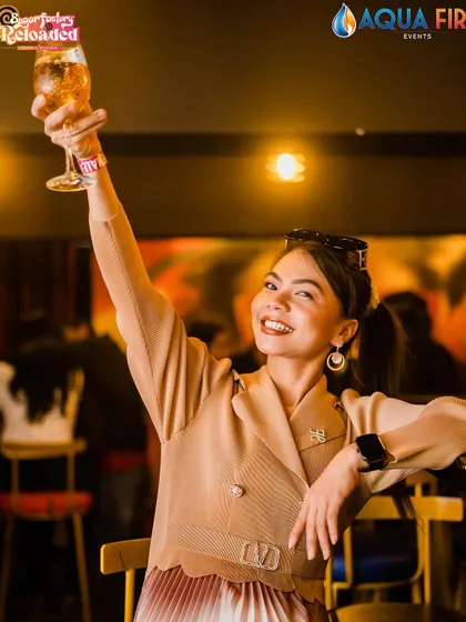 A guest raising a toast to the camera.