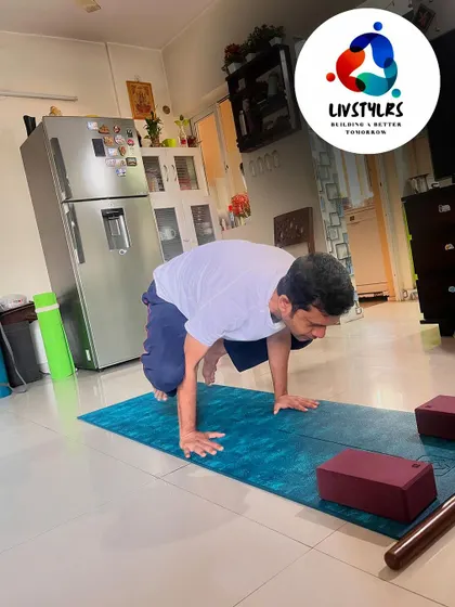A client holds a crow pose, demonstrating impressive arm and core strength.