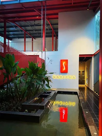 A night view of the Saritha Serene office, where the blend of architecture and landscape architecture is most apparent. The illuminated water feature and the bold red structure create a memorable and artistic composition.