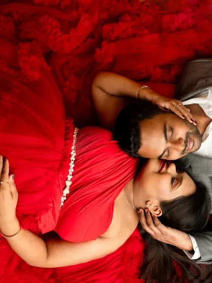 Couple portraits are about capturing your connection before the new arrival. This top-down shot in a vibrant red gown creates an intimate and visually striking memory for you and your partner.