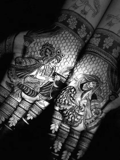A striking black and white photo of a Radha Krishna mehndi design, emphasizing the contrast and intricate line work.