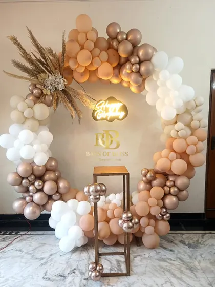 A beautiful boho-themed birthday ring backdrop. This full circle is adorned with neutral-toned balloons in cream and rose gold, accented with pampas grass for a soft, rustic, and elegant look.