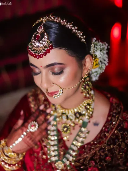 A duplicate of a classic bridal portrait, this image continues to emphasize the bride's serene beauty and the opulence of her wedding attire under dramatic lighting.